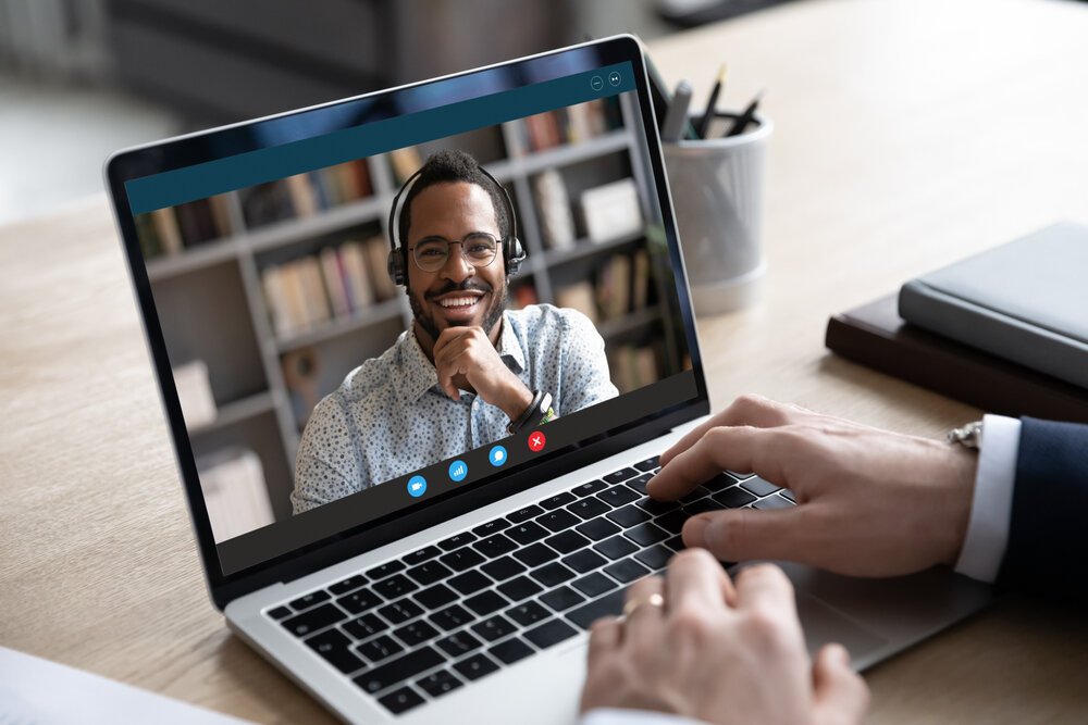 A man on a laptop screen discussing how to hire remote employees