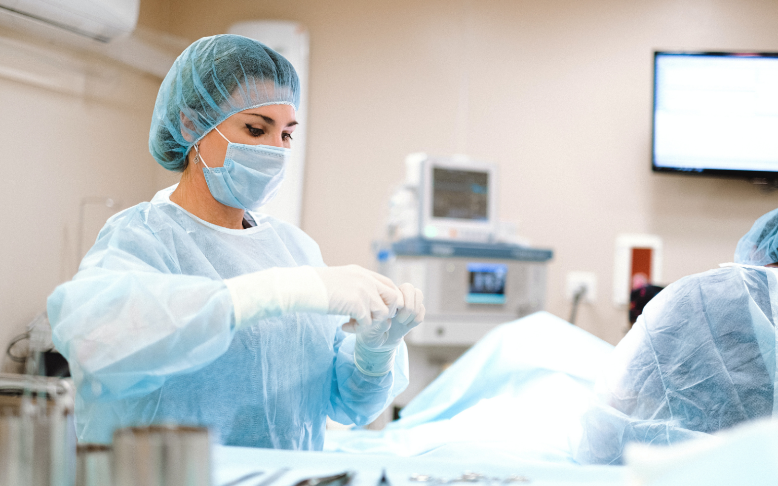 A lady in scrubs performing an operation whilst thinking about how a digitally enabled NHS would benefit her