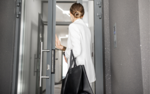 A young woman leaving a building, she has decided to quit adding to the business' already very high turnover of staff