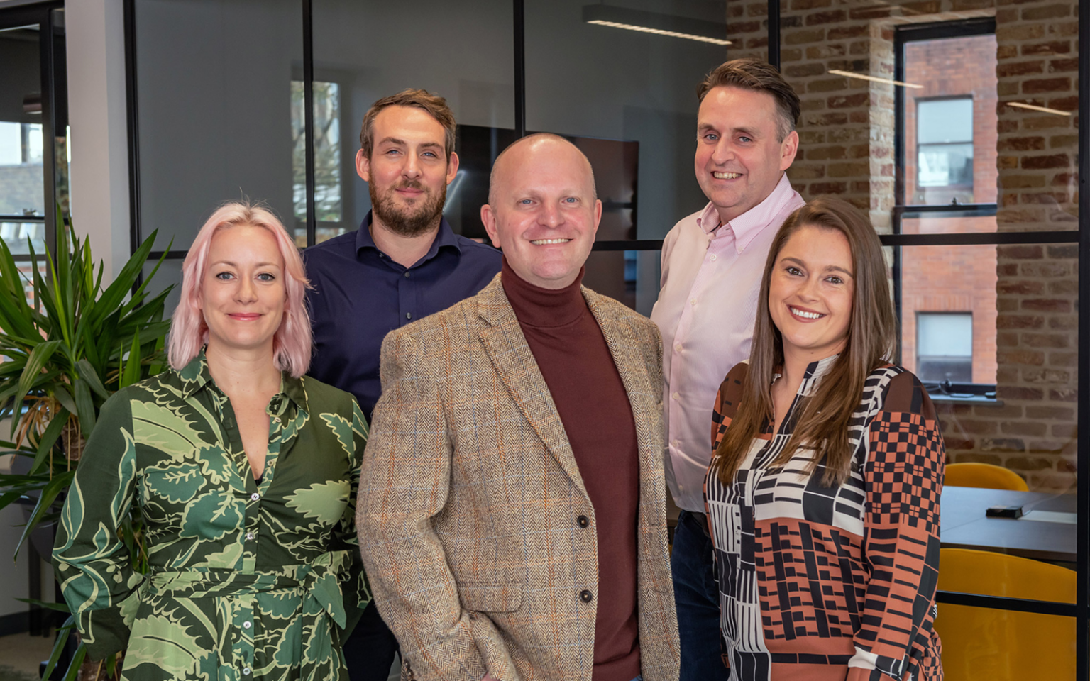 Five people standing in an office, including Hannah Parsons, Nicholas Hopkins, Matt Collingwood, Mike McEvoy and Danielle Keegan.