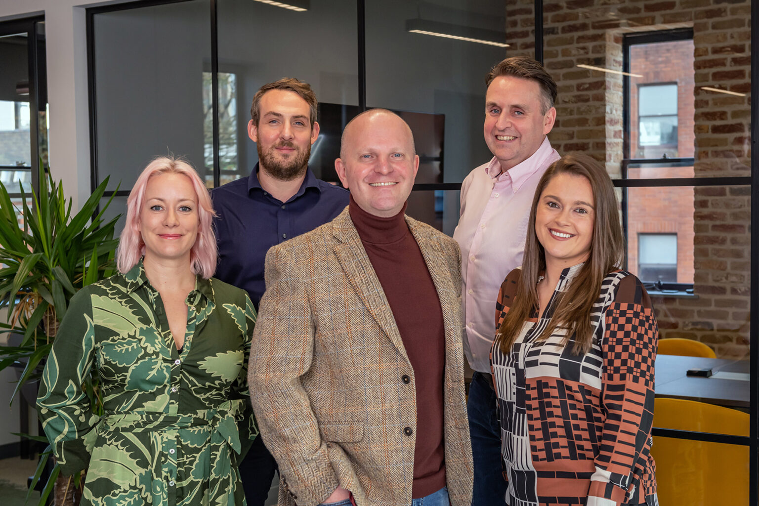 Five people standing in an office, including Hannah Parsons, Nicholas Hopkins, Matt Collingwood, Mike McEvoy and Danielle Keegan.