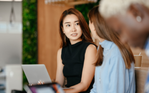 A woman in a black top sitting talking with another woman about the signs of a bad hire