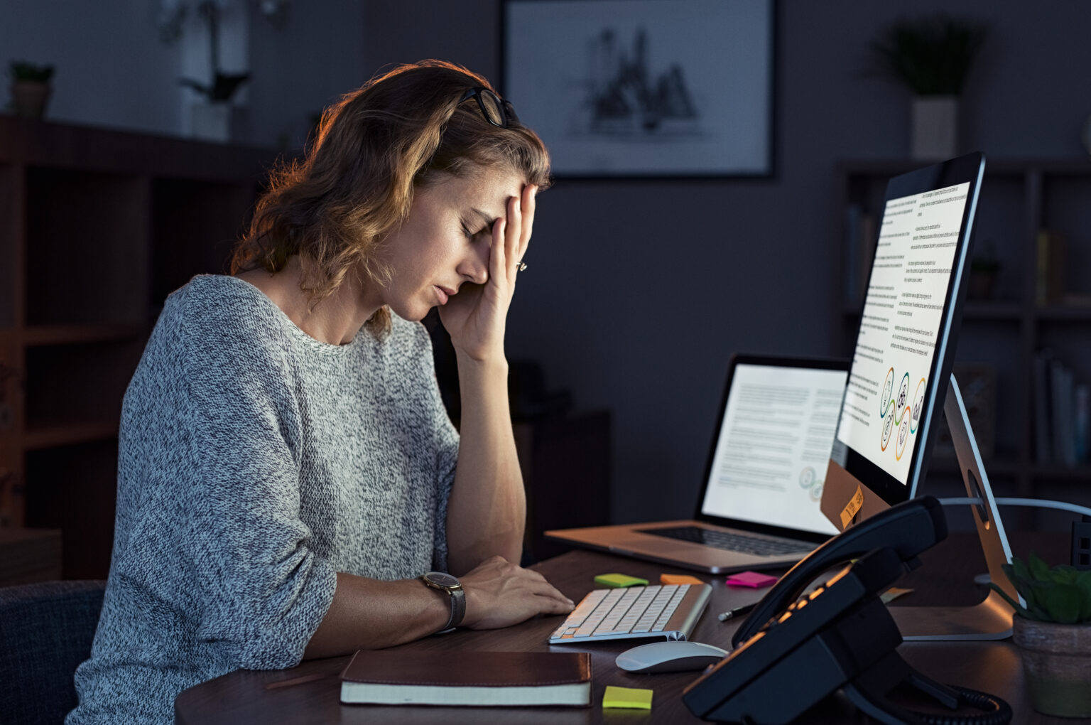 Woman looking stressed at computer due to high levels of burnout in the workplace