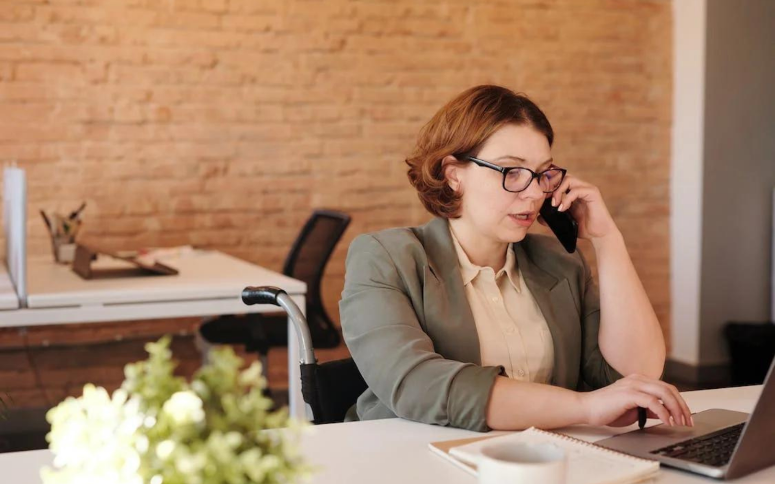 Women using the list of questions to ask a recruiter before an interview to call her recruiter and get the insights she needs to secure the role.