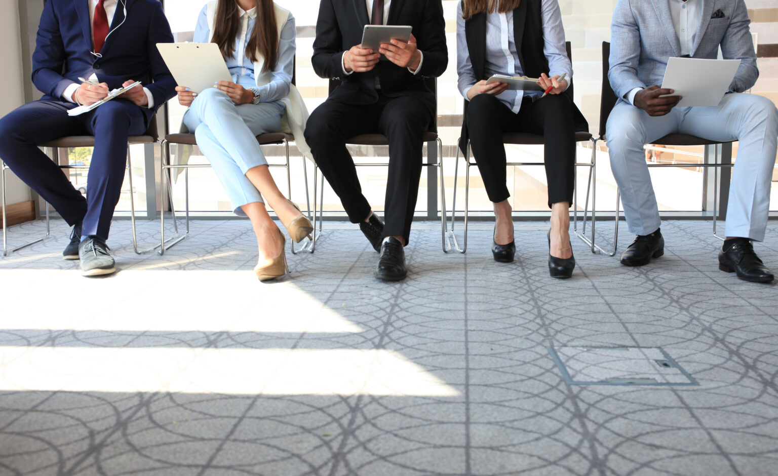 individuals sitting on chairs reading about the 2024 recruitment trends