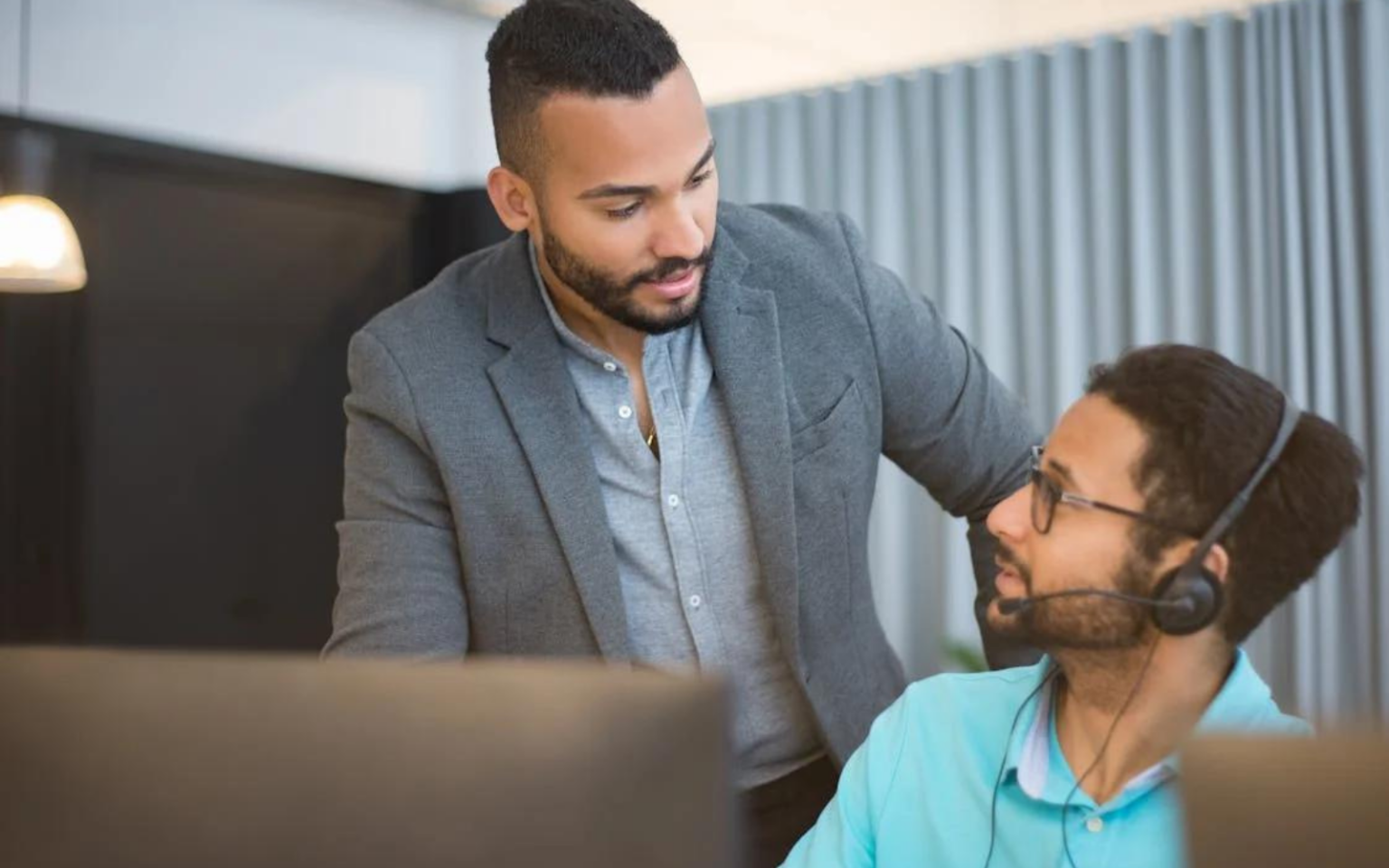 One recruiter helping another by talking to them about good mental health in recruitment practices for him to follow