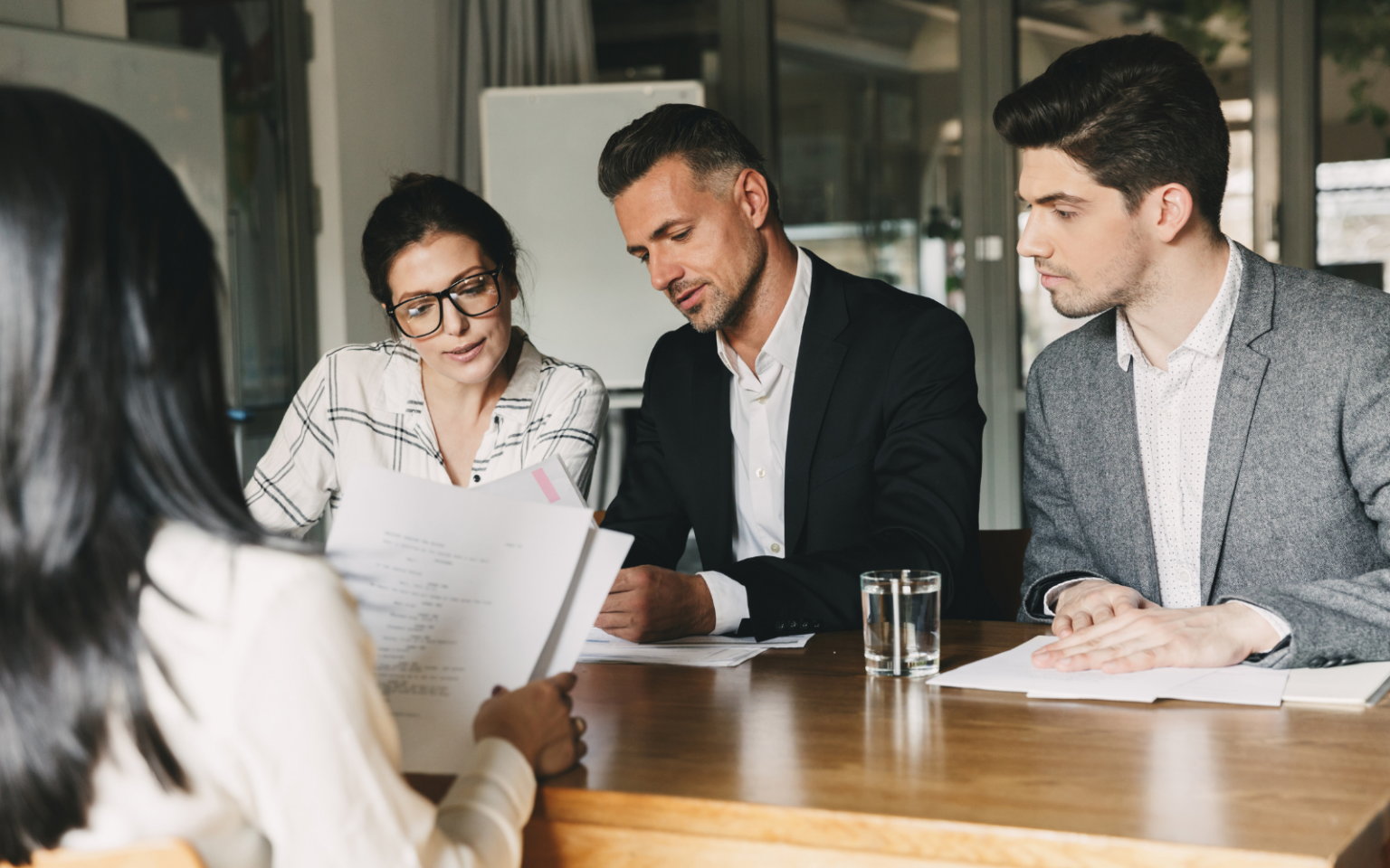 3 professionals at a table working out how to build a hiring comittee