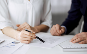 Two business people looking at a piece of paper that answers whether recruitment agencies are regulated