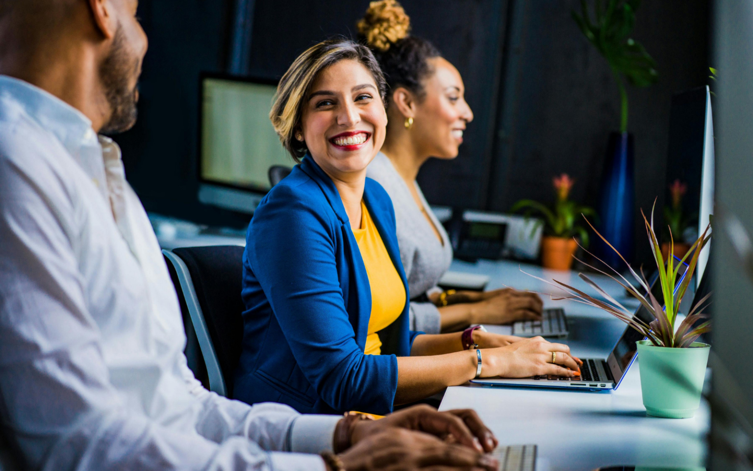 woman smiling at work because her organisation have listened to advice on the best ways of retaining women in the workplace